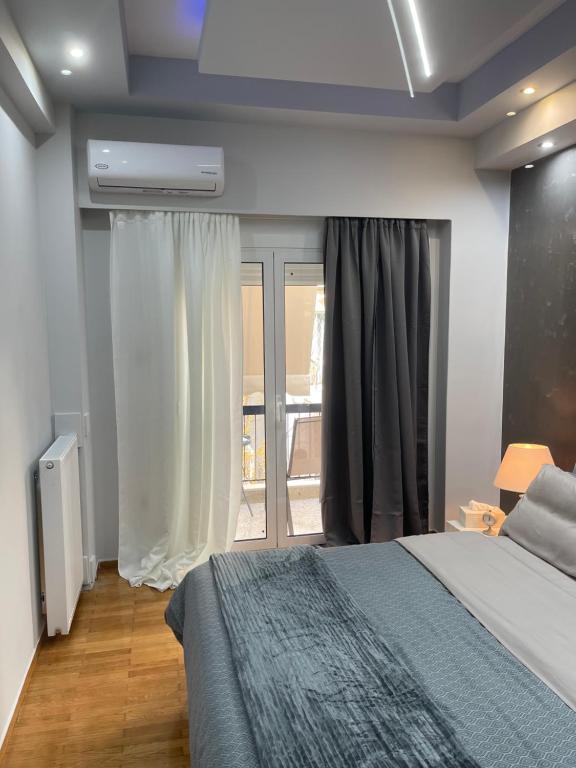 a bedroom with a bed and a large window at Maria's luxury apartment in Athens