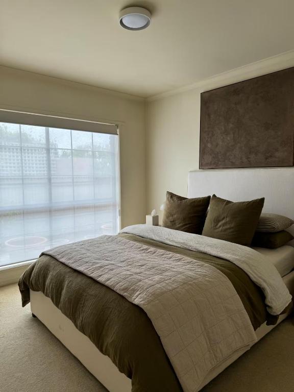 a bedroom with a large bed with a large window at Interior Stylist's Country Unit in Nhill