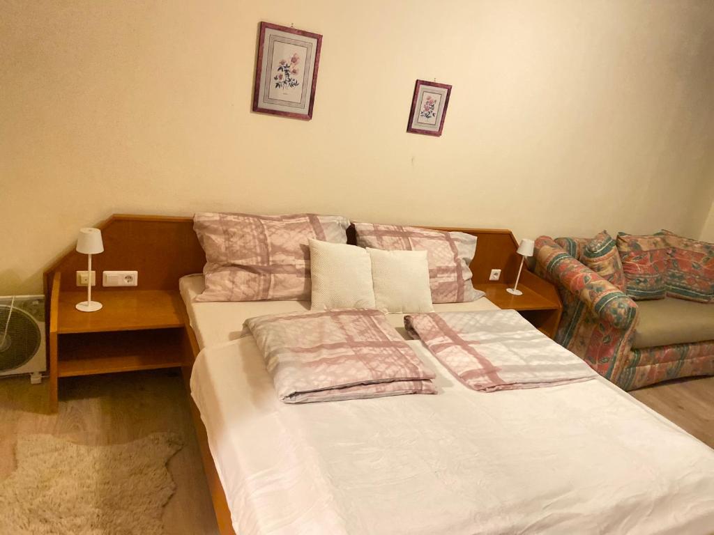 a bedroom with a bed with pillows and a couch at Zimmer in Plankenberg
