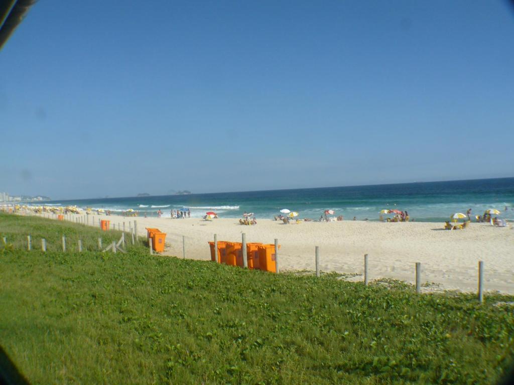 een strand met mensen op het zand en de oceaan bij Dolce Vita Residence in Rio de Janeiro