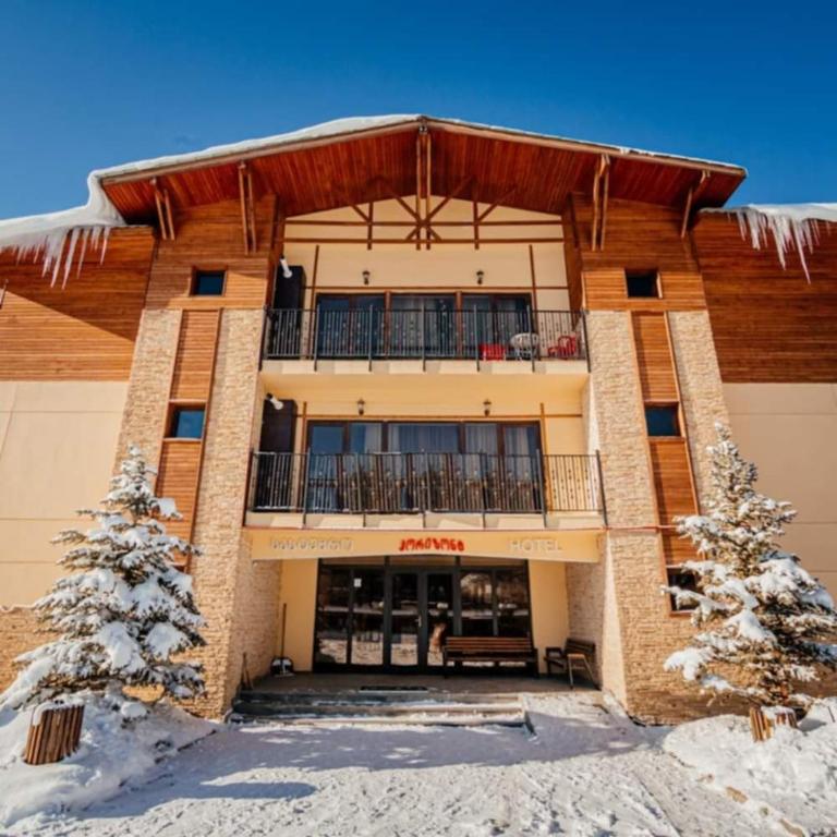 a building with a balcony in the snow at Horizont-apartment11 in Bakuriani