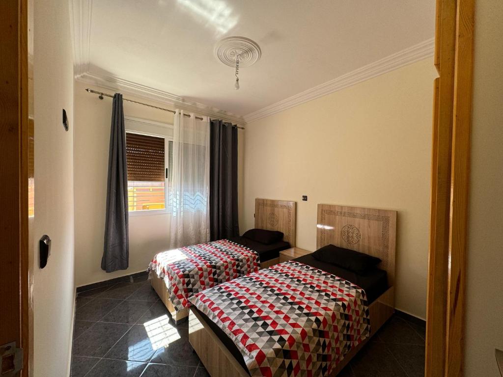 a room with two beds and a window at Saidia Appartement a Louer in Saïdia