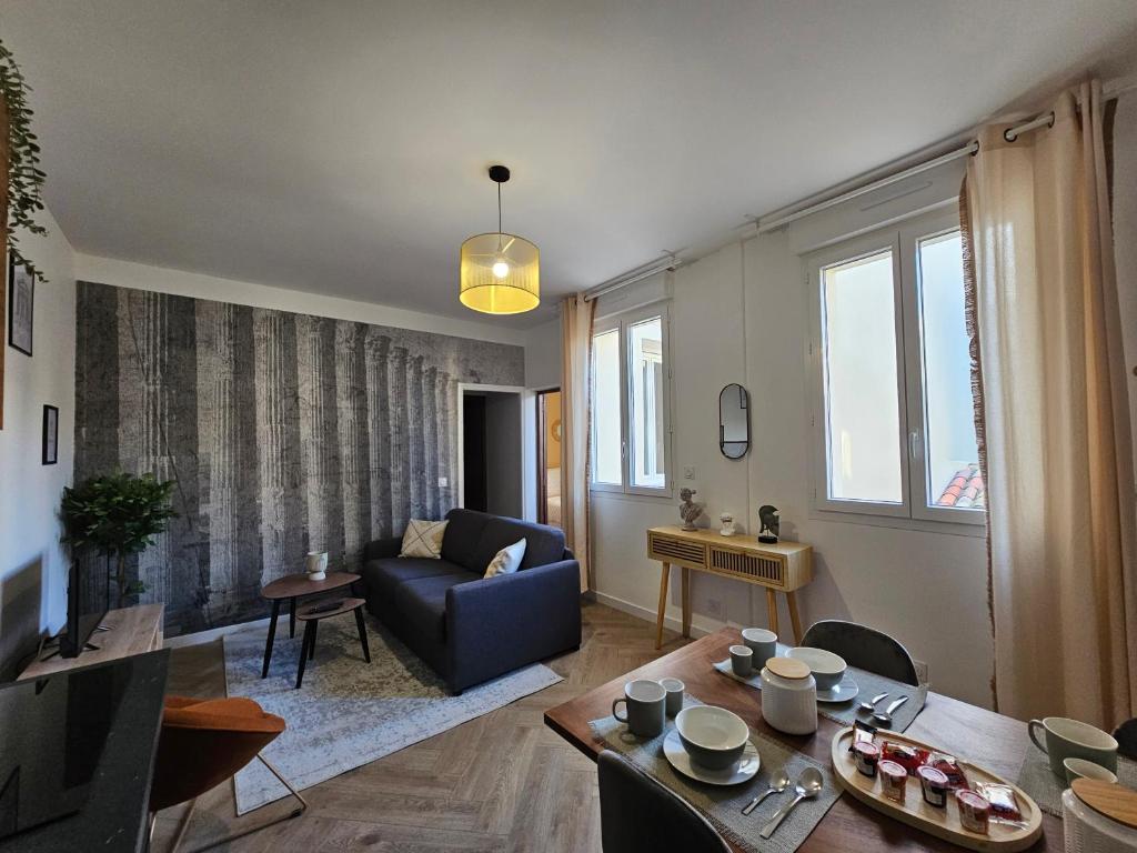 un salon avec un canapé et une table dans l'établissement Les élégantes colonnes de la Place Saint Charles, à Nîmes