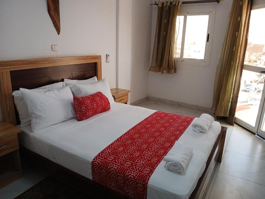 姆布尔Touraco Suite Hôtel Business的一间卧室，床上有两个红色枕头