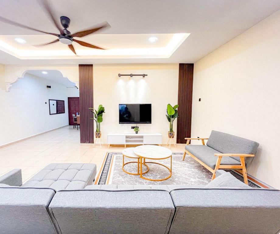 a living room with a couch and a tv at Homestay Desa (Bukit Baru, Melaka) in Melaka
