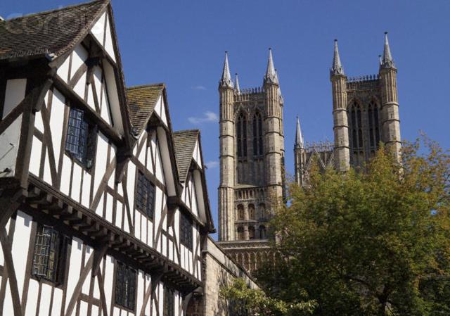 un edificio antiguo con una catedral en el fondo en Pemberton House, en Lincoln