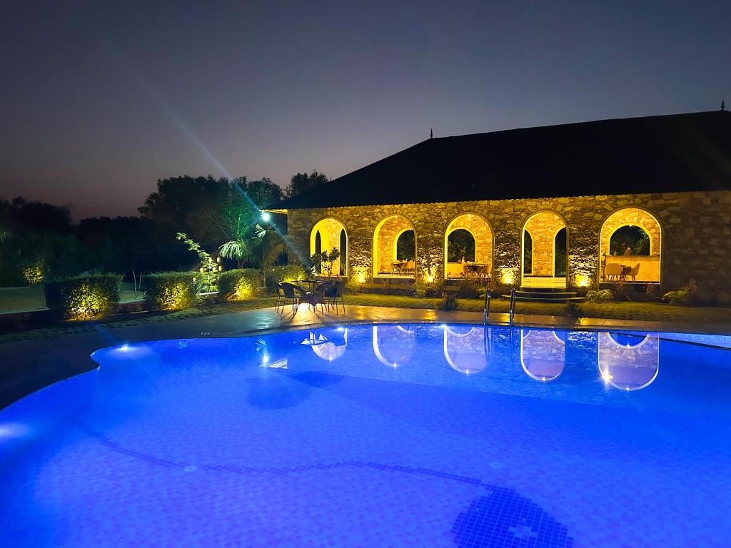 a large swimming pool in front of a building at night at Jawai's Wildness Lodge in Bera