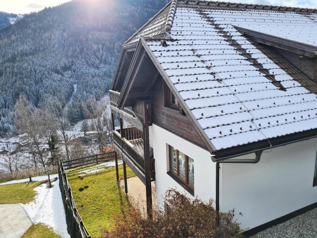 dom ze śnieżnym dachem na górze w obiekcie Haus Emma by Globalimmoservice w mieście Bad Kleinkirchheim