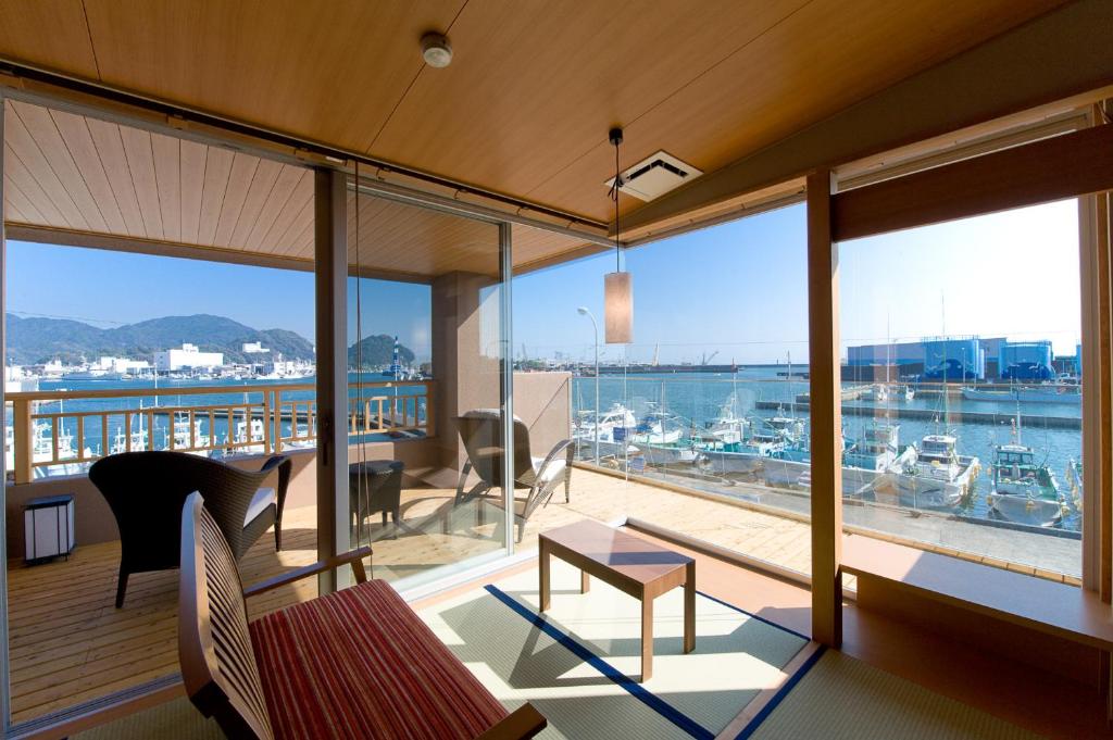 a room with a balcony with a view of a marina at Migiwaya in Yaizu