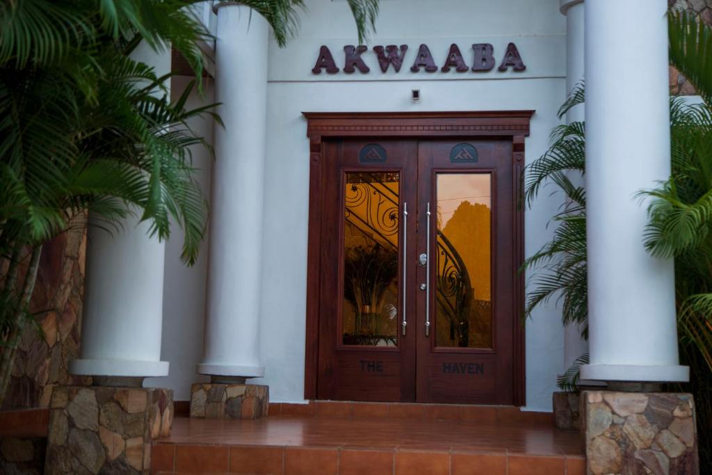 een toegang tot een gebouw met een houten deur bij The Haven Boutique Hotel in Kumasi