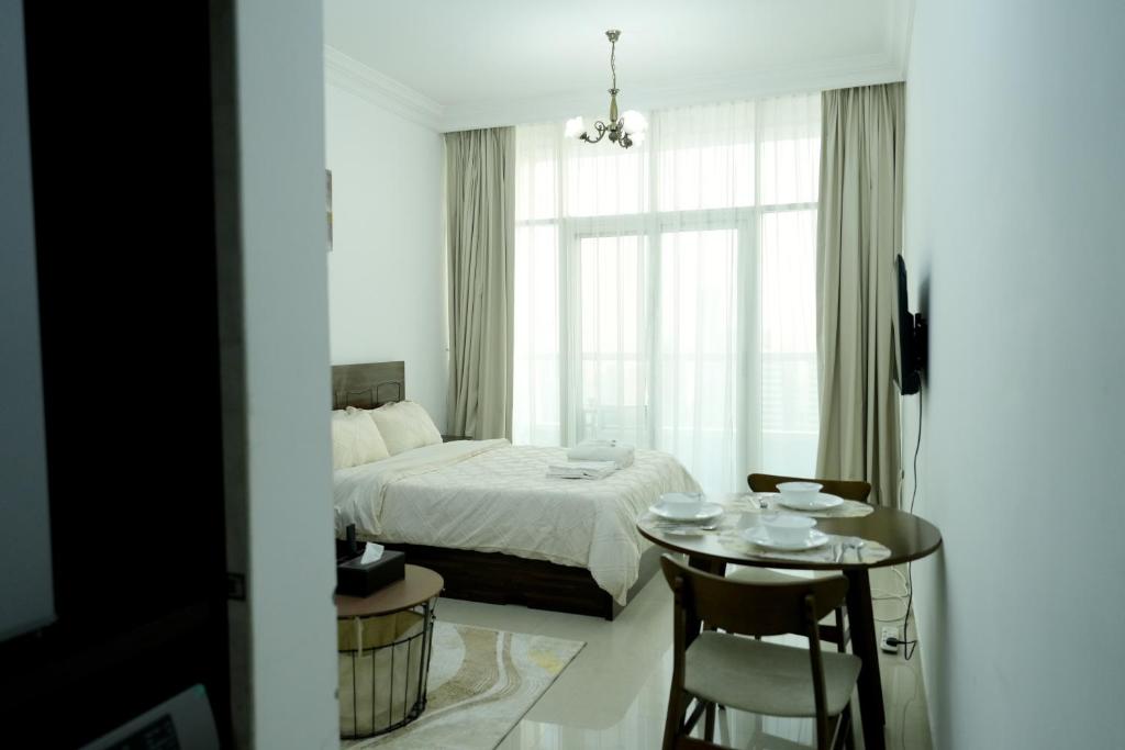 a bedroom with a bed and a table and a window at Cozy Private Studio -Near Beach -City View -Downtown Sharjah - Pool & Gym in Sharjah