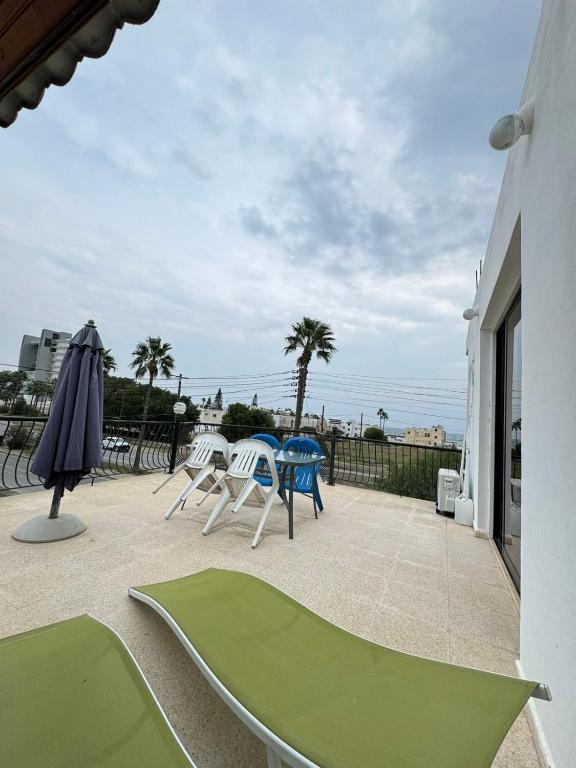 a patio with chairs and a table and an umbrella at Sea Apartments in Larnaka
