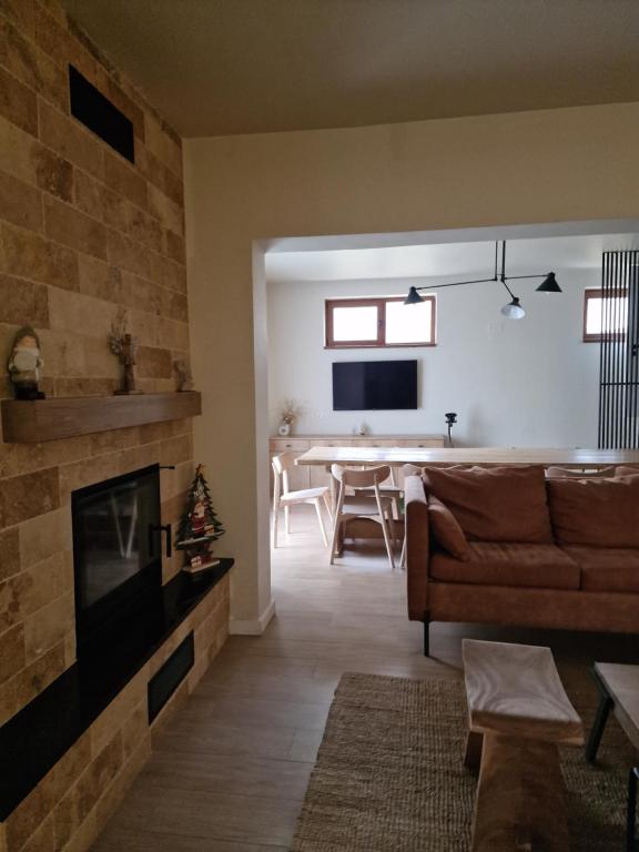 Una sala de estar con un sofá y una chimenea. en Cabana Marama, en Bratca
