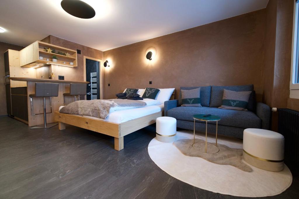 a bedroom with a bed and a couch at Studio NINNI in Zermatt