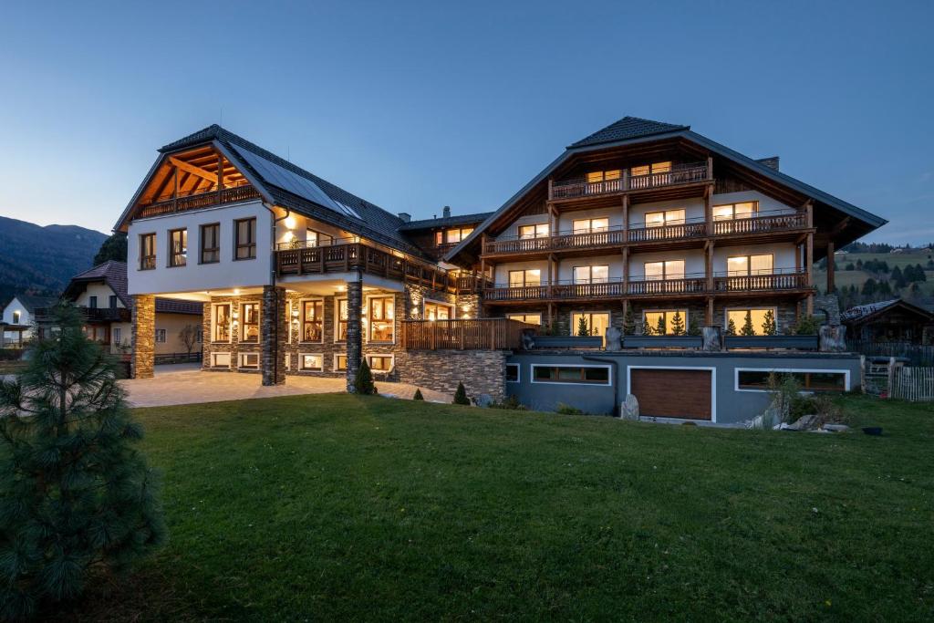 a large house with a garage in the yard at Hotel Haus Lungau in Mauterndorf
