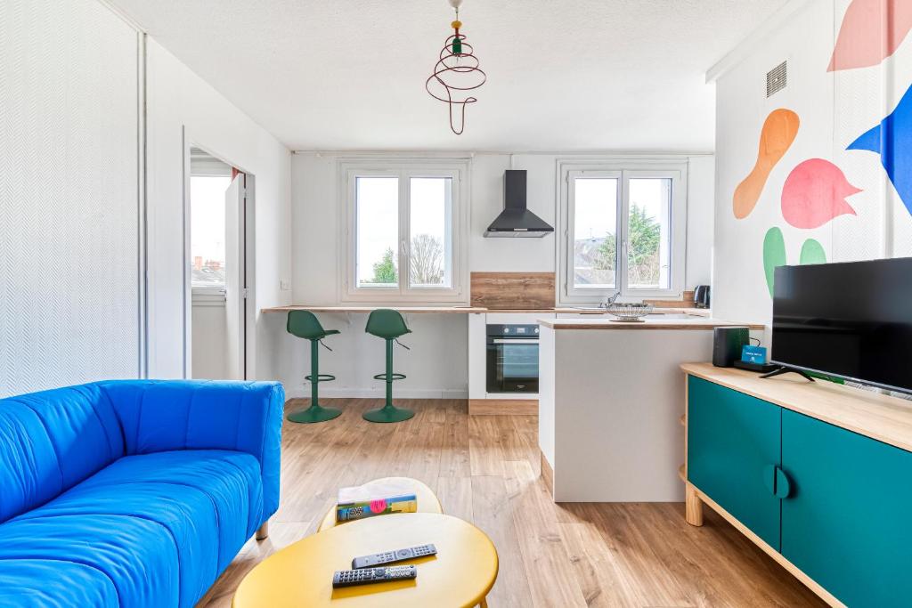 un salon avec un canapé bleu et une cuisine dans l'établissement Le Memphis - T2 Gare - La Bonne Marienne, à Angers