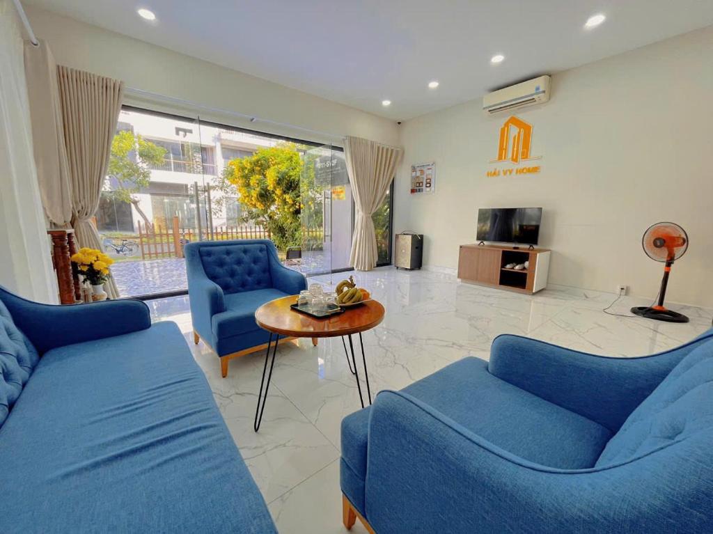 Una sala de estar con dos sofás azules y una mesa. en Sonasea Villas Phu Quoc, en Phu Quoc