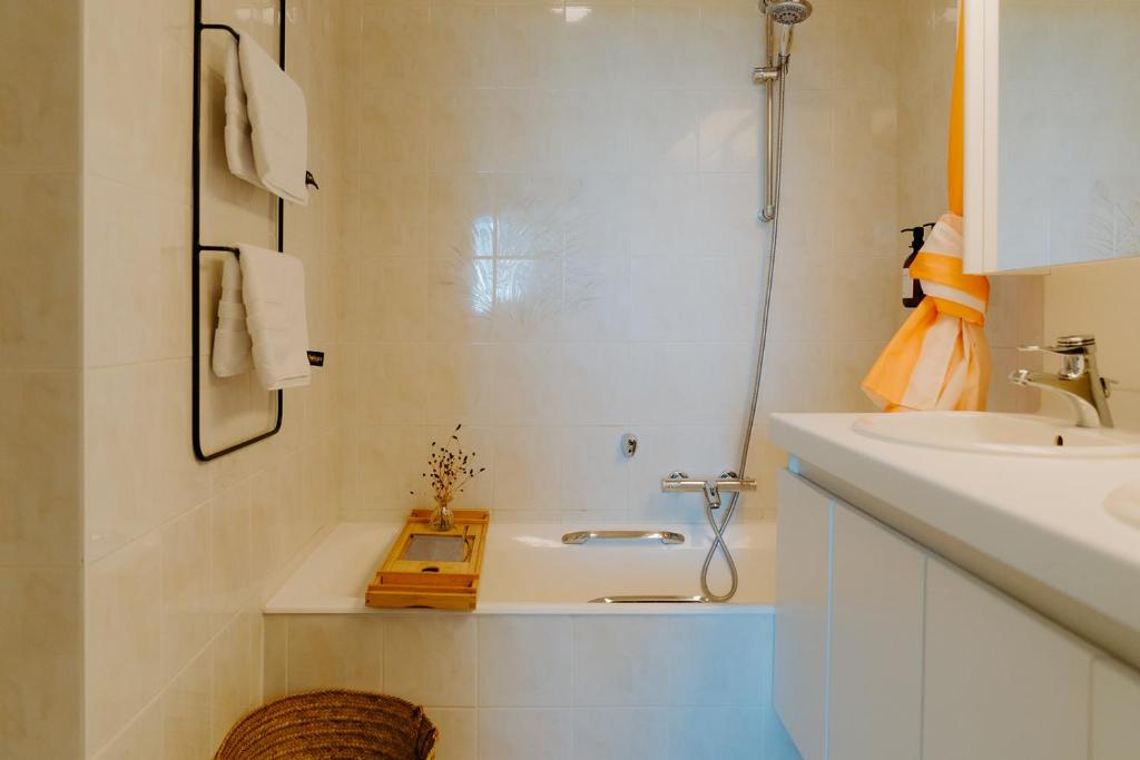 a bathroom with a sink and a bath tub and a sink at Prachtig, rustig en ruim appartement vlakbij zee in Koksijde