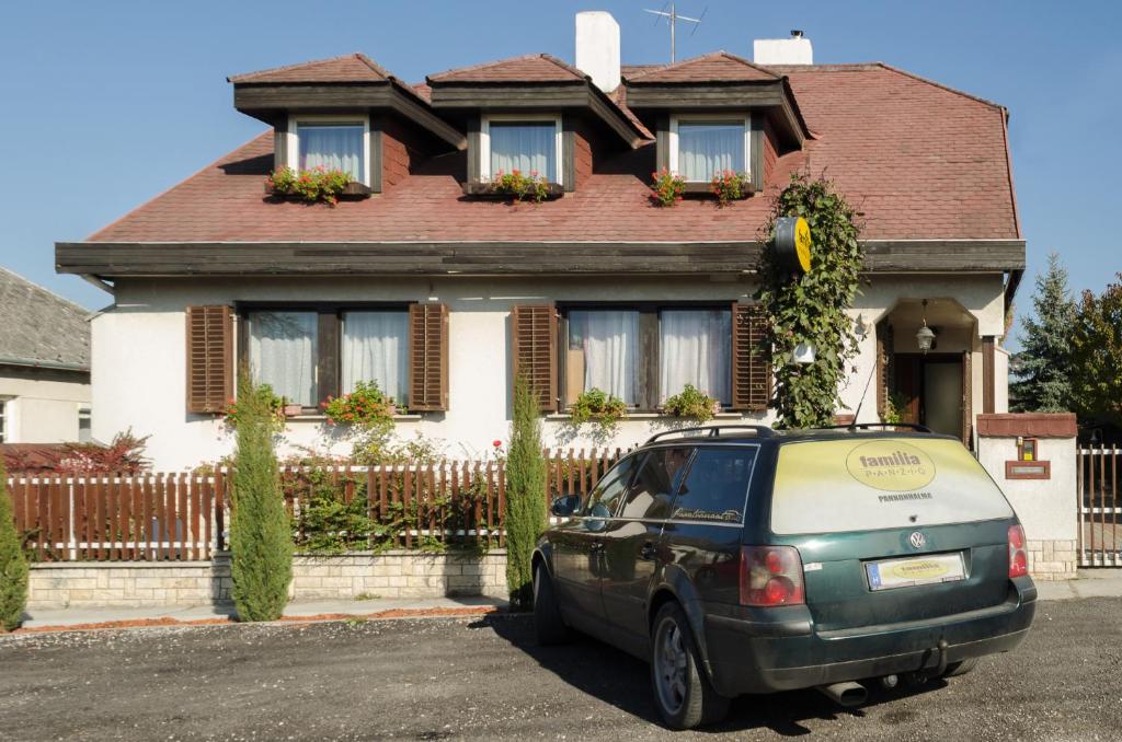 a car parked in front of a house at Família Panzió in Pannonhalma