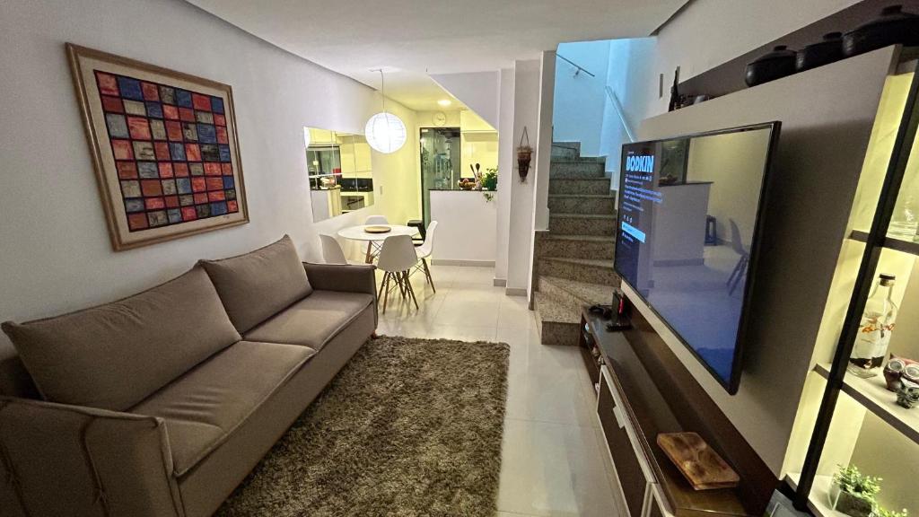 a living room with a couch and a flat screen tv at Descanso e Tranquilidade em Guaratiba in Rio de Janeiro