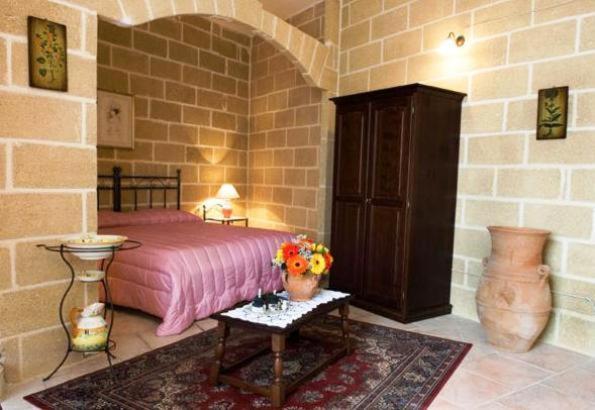 a bedroom with a bed and a table with flowers on it at Residenza De Leonardis in Alberobello