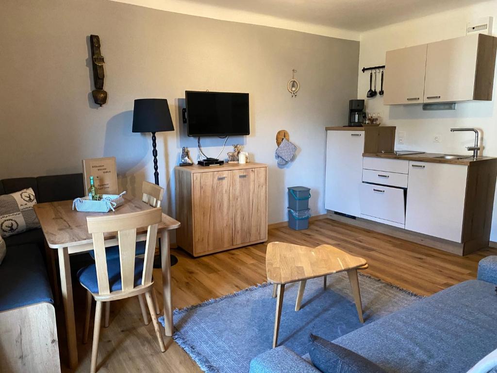 デーブリアッハにあるAppartement Kuhglocken Ferienhaus Fuenf Sinneのテーブルとキッチンのあるリビングルーム