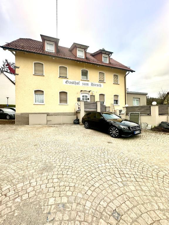 a black car parked in front of a building at Pension Hirsch in Berg