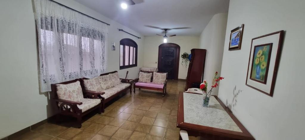 a living room with two couches and two chairs at Casa na praia das Astúrias in Guarujá