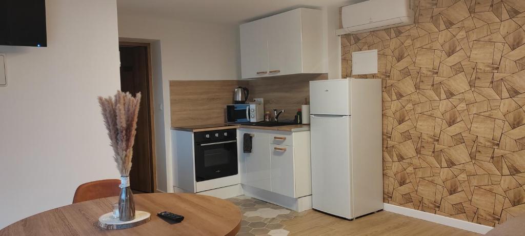 a kitchen with a white refrigerator and a table at Bel Appartement moderne in LʼHôpital