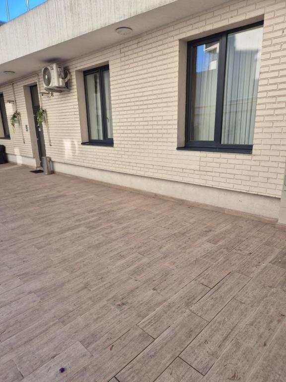 a brick building with a wooden floor in front at Avrig Dinu in Bucharest