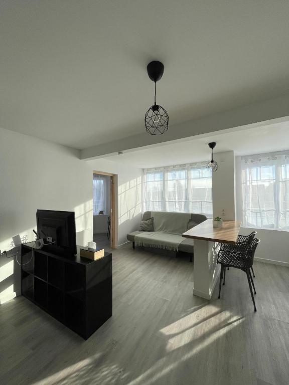un salon avec un canapé et une table dans l'établissement Appartement moderne, à Montrichard