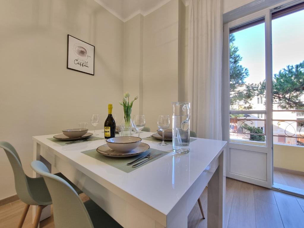 Hotel Casa Amalia, a white dining room with a table with wine glasses at Casa Amalia in Sanremo