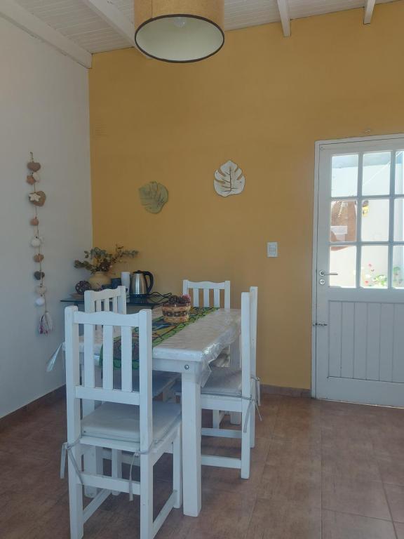 a dining room with a white table and chairs at Departamento Cerca Parque Termal Rodo-Hue 2 in Dolores
