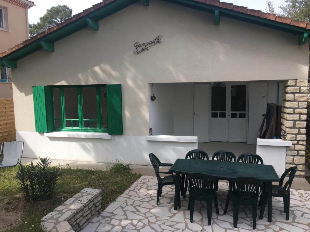 un patio avec une table et des chaises devant une maison dans l'établissement Villa Gazouillis, à Saint-Georges-de-Didonne