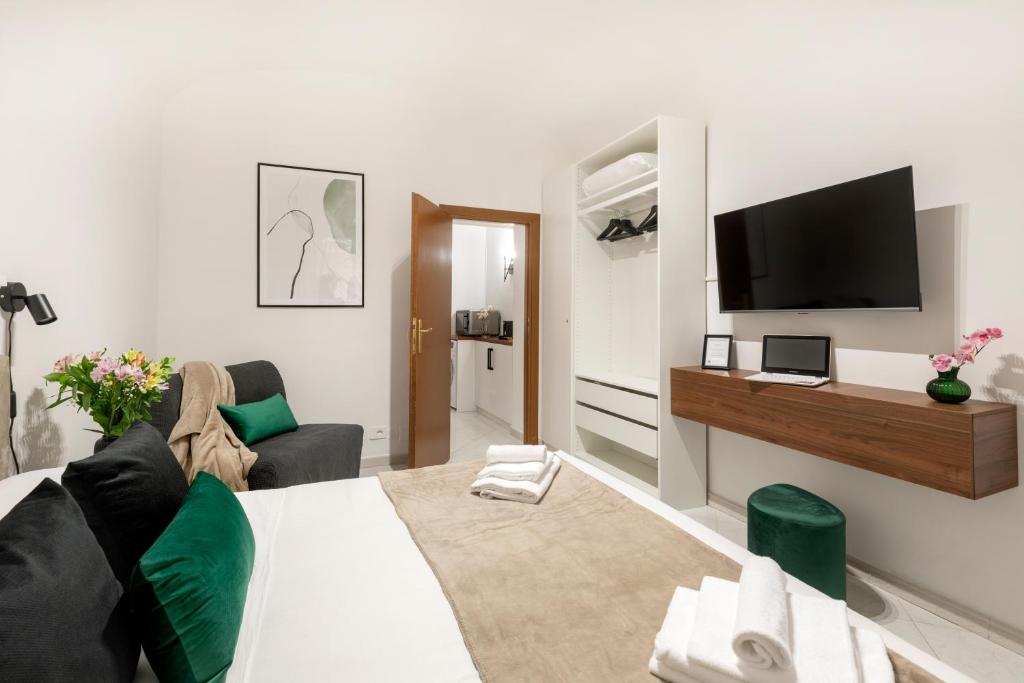 Una sala de estar con un sofá y un televisor en una pared. en White Flat Sanniti, en Roma