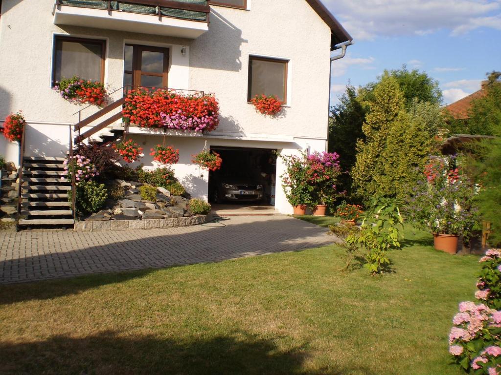 a white house with flowers on the side of it at Apartment Za Poštou in Bělkovice