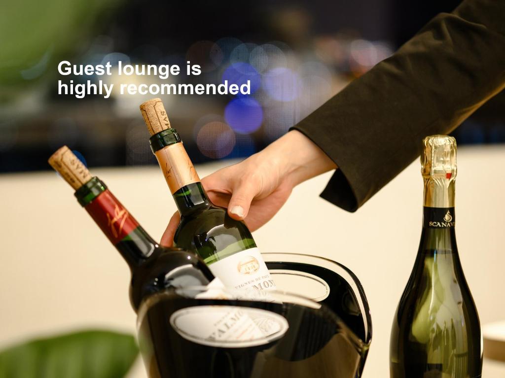 a person reaching for two bottles of wine at Mitsui Garden Hotel Hiroshima in Hiroshima