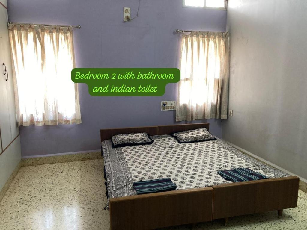 a bedroom with a bed with curtains and a sign on it at decent home stay in Belgaum