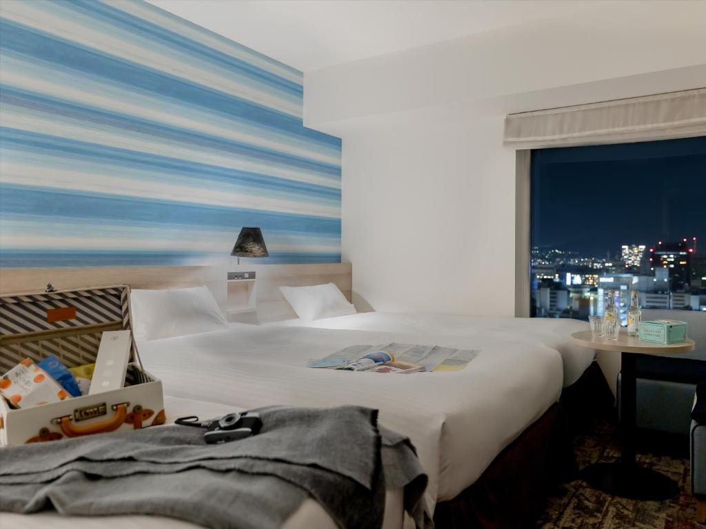 a hotel room with two beds and a window at Mitsui Garden Hotel Hiroshima in Hiroshima