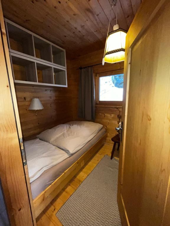a small bedroom with a bed in a wooden room at Walters Hütte in Tulfes