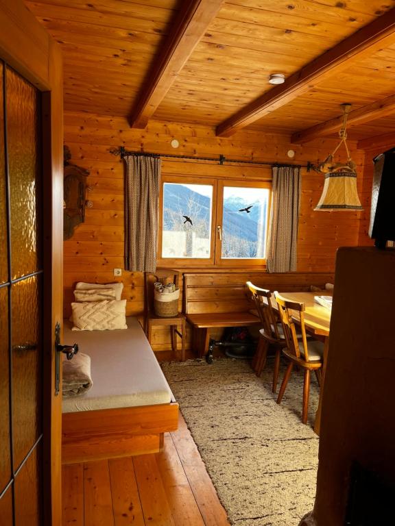 a room with a table and a bed in a cabin at Walters Hütte in Tulfes