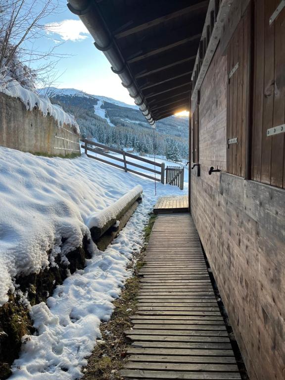 a wooden walkway next to a building in the snow at Walters Hütte in Tulfes