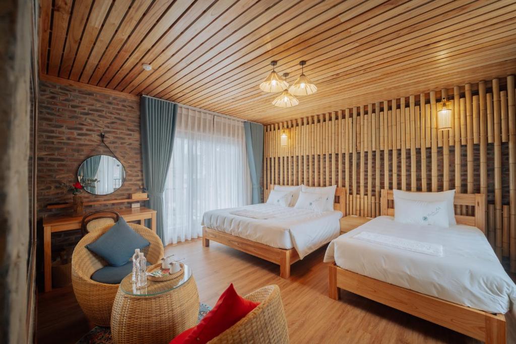 a hotel room with two beds and a chair at Xuân Anh Garden in Ninh Binh