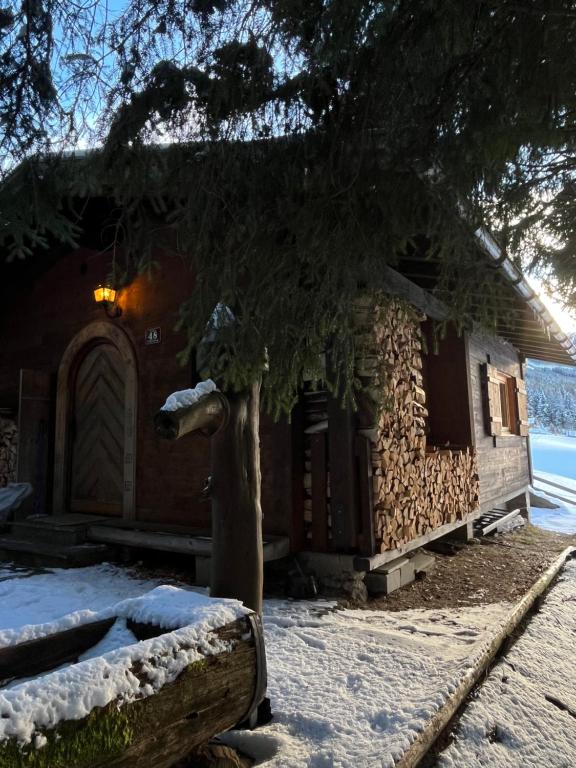 a log cabin in the snow next to a building at Walters Hütte in Tulfes