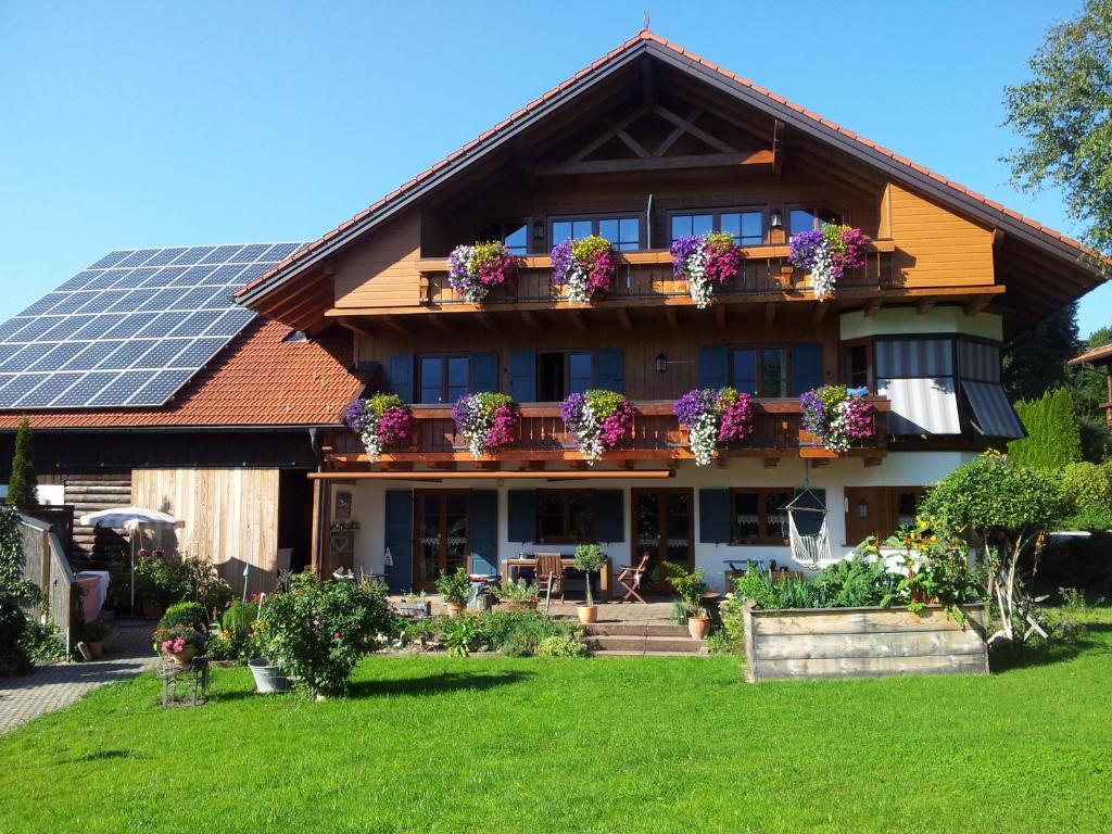 ein Haus mit Blumen auf dem Balkon mit Solardach in der Unterkunft Landhaus Wanger in Pfronten