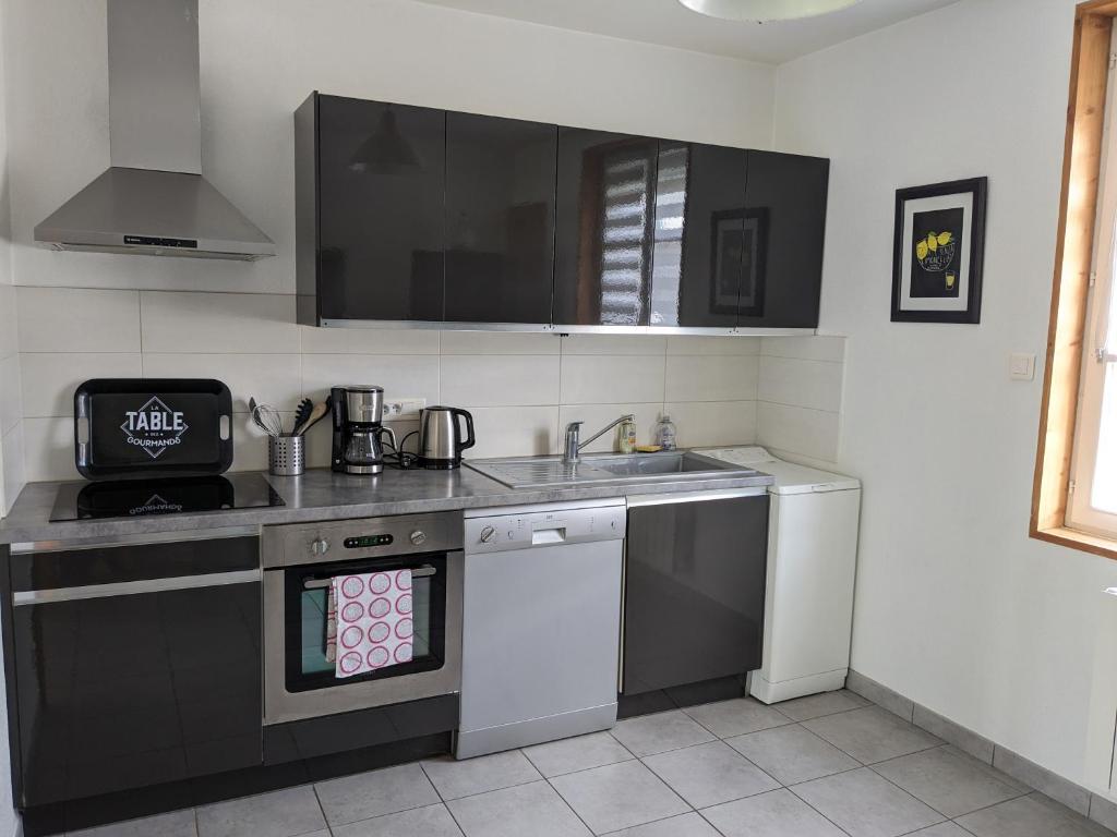 eine Küche mit Spüle und Herd oberen Backofen in der Unterkunft Maison de vacances cosy in Avranches