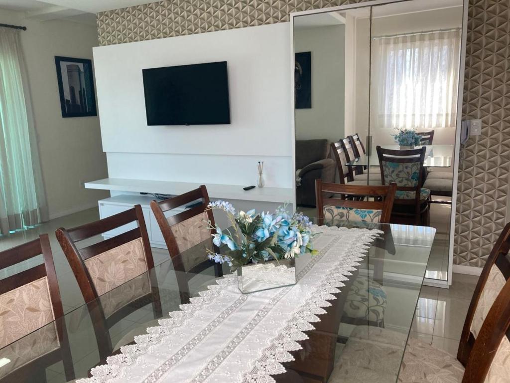 a dining room with a table with flowers on it at Apto 350 metros do mar com 2 garagens e ar condicionado in Meia Praia