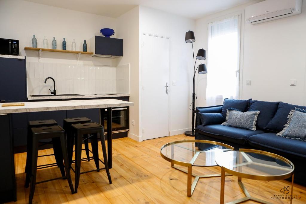 un salon avec un canapé bleu et une table dans l'établissement Le Jardin de Beau Pré - App 3-2 - Centre ville, à Perpignan