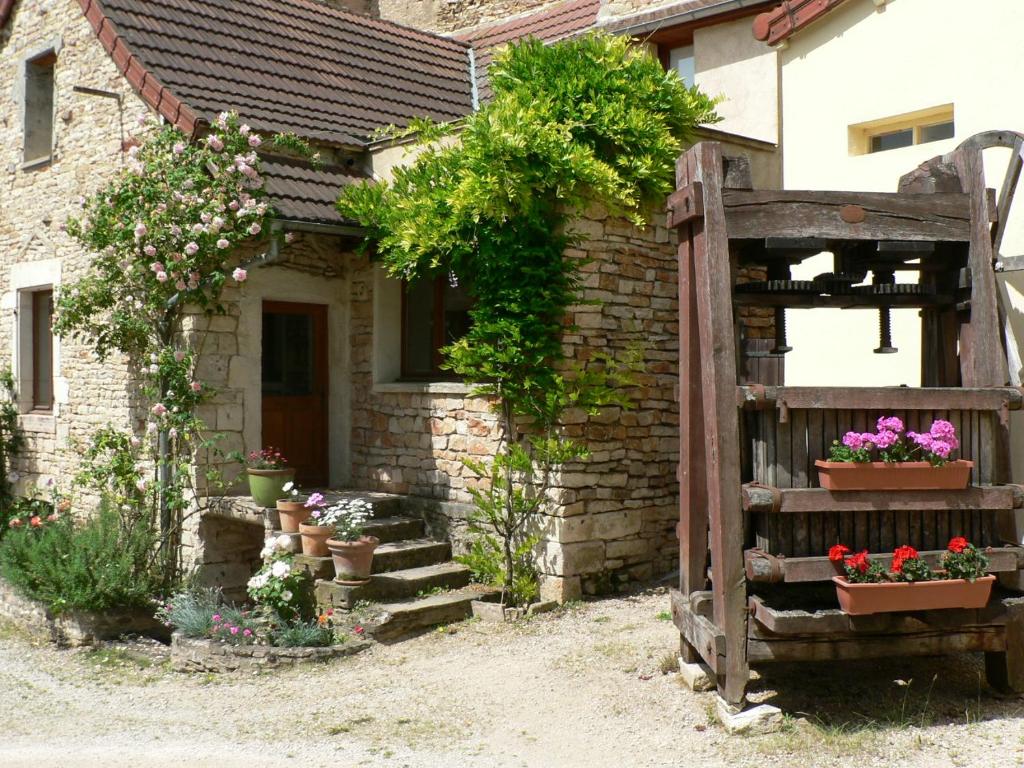 une maison avec des pots de fleurs et une porte en bois dans l'établissement Gite La Petite Maison - au coeur des vignes - Mercurey, à Saint-Martin-sous-Montaigu