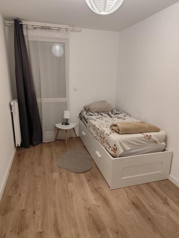 une chambre avec un lit et un parquet dans l'établissement Chambre cosy à Villeurbanne, à Villeurbanne